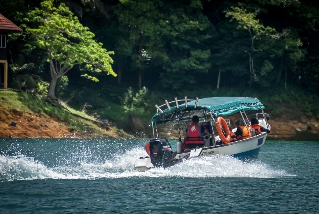 A motorboat cuts through a scenic river surrounded by lush forest, ideal for outdoor adventure imagery.