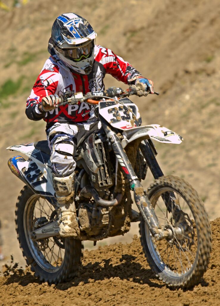 Exciting motocross action with dirt bike rider in full gear on a challenging track.