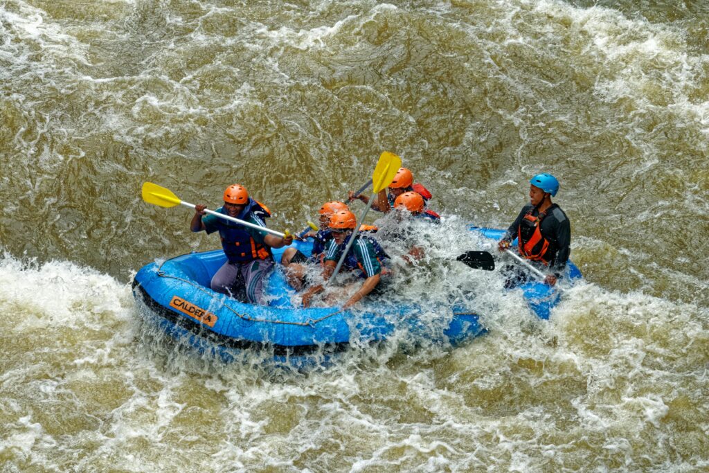 Adventurous group rafting through rapids in Cikidang, West Java, Indonesia.