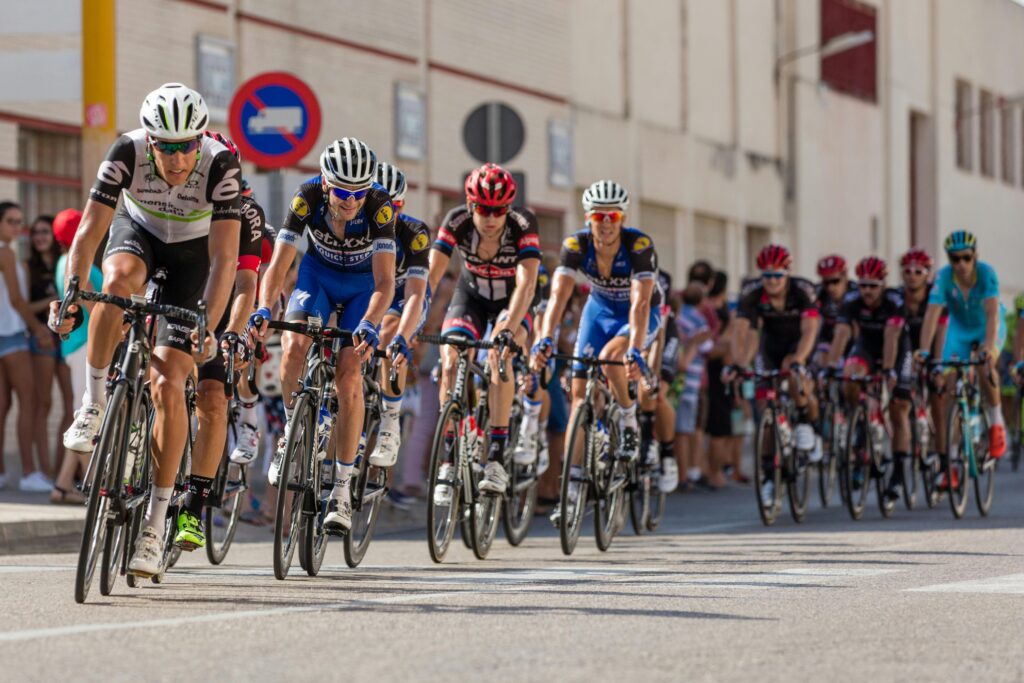 Dynamic photo of professional cyclists racing on a city street, showcasing speed and athleticism.