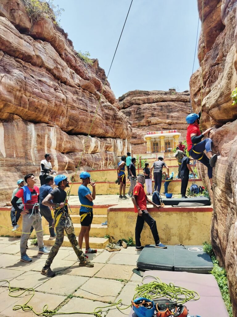 Rock climber on an orange sandstone route in Badami, Karnataka